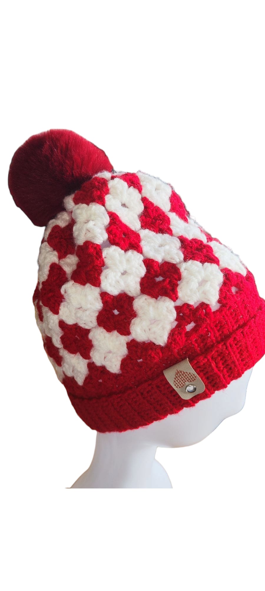 Flat lay of the red and white granny square beanie showing bold contrast colors and intricate hand-stitched design.
