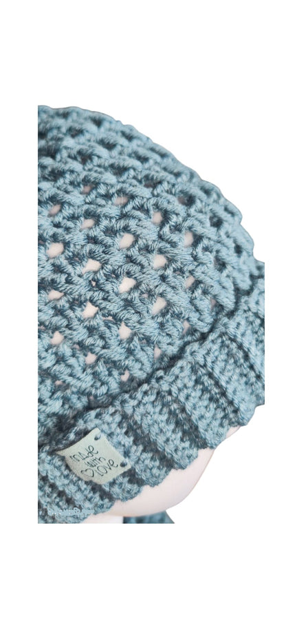 Close-up of the Sky Blue winter set showing the rich crochet pattern and golden pom-pom on the beanie.